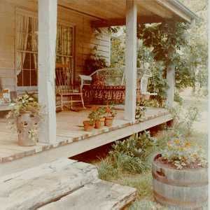 Country Front Porch    Wood porch floors made of pressure treated lumber are excellent for a country house since they are easy to maintain. No mud stains from friendly pets will remain as in the case of a concrete porch floor. Rough 6x6 inch posts are used with steps sawn from a large log. An old wicker couch is made into a porch swing. Country Front Porches, Unique House Plans, Country Porch, Porch Flooring, Unique Houses, Country House Plans, Decks And Porches, Porch Patio, Porch Swing