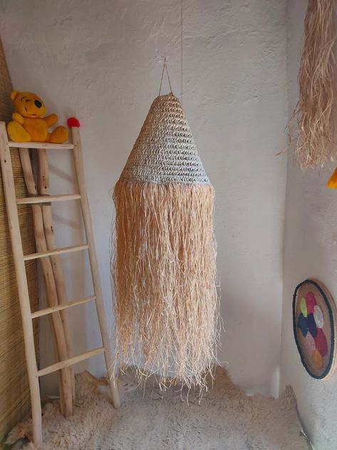 Handmade boho lampshade , suspension pendant light , straw wicker lampshade , palm leaf with raffia lamp . raffia and straw lampshade , boho pendant light , raffia lampshade , long raffia suspension light . the uniquely designed rattan lamp shade is handcrafted and will surely be an eye - catcher in the room you hang it in . Gives a very warm glow when lit . The raffia edge adds the perfect coastal boho look . this wonderful lampshade can be hung in the living room , nursery and hallway . Straw Lampshade, Raffia Lamp, Boho Lampshade, Boho Pendant Light, Raffia Lampshade, Rattan Lamp Shade, Wicker Lampshade, Living Room Nursery, Rattan Lamp
