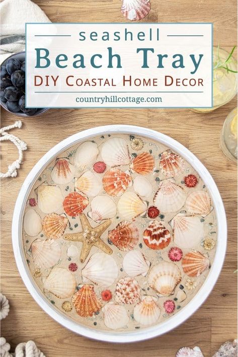 How to make a modern round wood DIY beach tray with seashells! The easy seashell craft is a fun summer craft project and rustic farmhouse coastal decor. The step-by-step makeover tutorial includes ideas for materials and working with epoxy resin to create a homemade white painted wooden seashell serving tray with gold trim! Elegant as living room decor, coffee table centerpiece, kitchen display, custom tea tablet, or outdoor party. #servingtray #tray #homedecor #coastal| CountryHillCottage.com Seashell Display Coffee Table, Epoxy Resin Seashell Table, Seashell Epoxy Table, Wood Resin Tray Ideas, Fast Diy Crafts, Seashell Jewelry Diy How To Make, Resin Crafts With Seashells, Epoxy Resin And Sea Shells, Resin With Shells