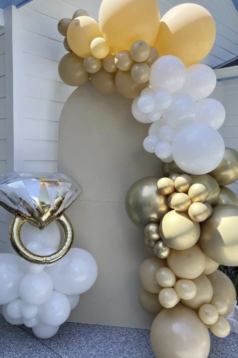 Planning an unforgettable engagement celebration? Elevate your decor with our stunning engagement balloon ring and balloons! Create picture-perfect moments against a rustic wooden backdrop for a romantic atmosphere that's second to none. Dive into the world of Pinterest for more engagement party inspiration! He Popped The Question Engagement, Engagement Ring Balloon Decor, Engagement Party Background, Engagement Party Balloons Decor, Surprise Engagement Party Ideas Decor, Engagement Party Balloon Garland, Engagement Brunch Decorations, Engagement Party Boho, Balloon Arch Engagement