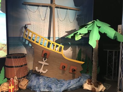 Shipwrecked VBS 2018 stage decorations - my palm tree from a carpet tube, umbrella and corobuff paper, ship made of foam board and a diy barrel from a cardboard box. Ocean Stage Decorations, Diy Shipwreck Decor, Boat Vbs Decorations, Cardboard Shipwreck, Shipwreck Diy, Peter Pan Diy Decorations, Shipwreck Vbs Decorations, Pirate Theme Vbs, Shipwrecked Vbs Decorations