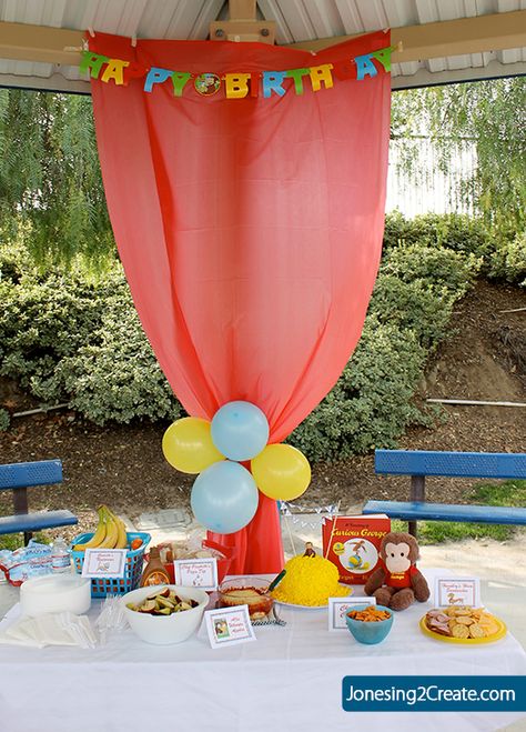 Dollar Tree tablecloth hung up to hide the poles... park birthday party.  I would use pink or purple though to match the theme Park Birthday Party, Party At The Park, Curious George Birthday Party, Birthday Party At Park, Curious George Party, Curious George Birthday, Park Birthday, Shower Bebe, Birthday Party Tables