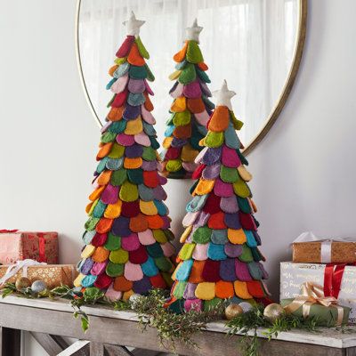 This unique handmade pair of felt trees includes all the colors of the rainbow. Dimensions: 36" & 26” tall. Each is topped with a simple white star. The trees make a lovely holiday table centerpiece. Put on an entry hall table or anywhere in the house for instant Christmas. They can also stand in as a "tree" for anyone who doesn’t have room for the full-sized version. A perfect gift for anyone who thinks that more trees make for a merrier Christmas! It’s a cheerful, untraditional take on holiday Patchwork, Natal, Multicolor Christmas Tree, Felt Trees, Multicolor Christmas, Christmas Topiary, Holiday Table Centerpieces, Holiday Tablescape, Christmas Lamp