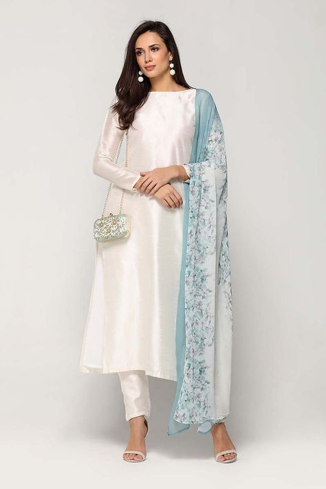 This lined straight silk dress with boat neckline, side slits and back zip is paired with matching lined silk trousers. The set comes along with a contrasting georgette floral print dupatta. Silk Kurti Designs, Salwar Designs, Salwar Kamiz, Kurti Designs Party Wear, Pakistani Dress Design, Indian Attire, Asian Outfits, Indian Fashion Dresses, Desi Fashion