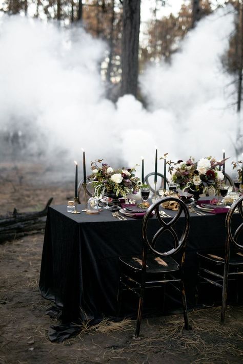 Dark and moody wedding reception tablescape with black table cloth, dark purple tapered candles,and burgundy and white floral centerpieces.| Moody Jewel-Toned Halloween Wedding Inspiration Shoot | #equalitymindedweddings #lgbtweddingmagazine #loveinc #halloweenwedding #halloween #floralcenterpiece #moodyweddingphotography Black Wedding Tables Ideas, Dark Moody Sweetheart Table, Simple Black Wedding Centerpieces, Simple Moody Wedding Centerpieces, Witchy Wedding Table Setting, Dark Rustic Wedding Decor, Spooky Wedding Centerpieces, Goth Wedding Table Decor, Dark And Moody Wedding Invitations