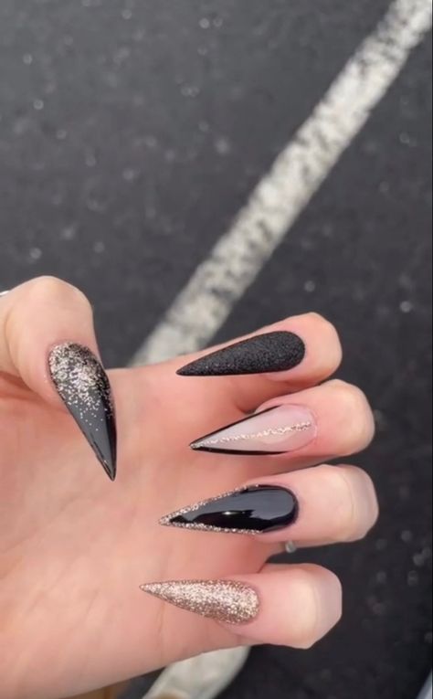 Black Christmas Nails Stiletto, New Year Stiletto Nails, Black And Sparkle Acrylic Nails, Black And Gold Sparkly Nails, January Nails Stiletto, Gold Pointy Nails, Black And Gold Nails Stiletto, New Years Stilleto Nails, Black Pointy Nails Designs