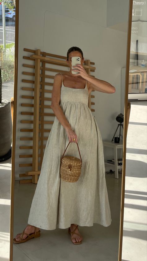 Women wearing full length linen dress. The dress is a neutral colour with thin straps, a fitted bust area and a flowy skirt Layering Sleeveless Dress, Summer Outfits Inspo Aesthetic, Italy 2024 Fashion, Punta Cana Outfits Resort Wear Packing Lists, How Does Pinterest See Me Fashion, Overalls Outfit Aesthetic Summer, 2024 Summer Dresses, Boho Chic Summer Outfit Ideas, Minimalist Vacation Outfits