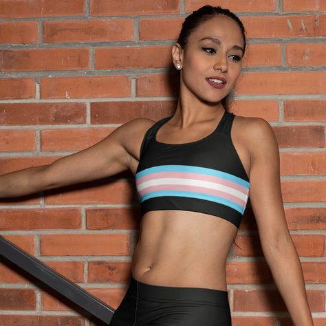 Work out in style and comfort whilst showing off your trans pride with this black sports bra accentuated with transgender flag stripes across the front and back. A beautifully soft and comfortable transgender pride sports bra top that comes in padded and non-padded versions. Very versatile, use for gym workouts, biking and yoga and as LGBTQ+ pride festival top. Team up with our matching transgender flag leggings. FEATURES Racerback style Moisture wicking fabric Outside printed Inside white Scoop