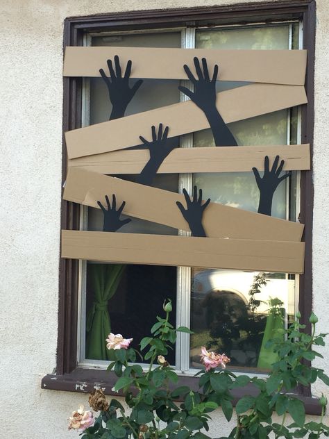 Cardboard boarded window with zombie hands Diy School Halloween Decorations, Diy Halloween Decorations Zombie, Zombie Apocalypse Outdoor Decorations, Diy Halloween Decor Cardboard, Halloween Decorations Diy Cardboard, Diy Halloween Window Decor, The Last Of Us Halloween Decorations, Zombie House Decorations, Spooky Window Decor