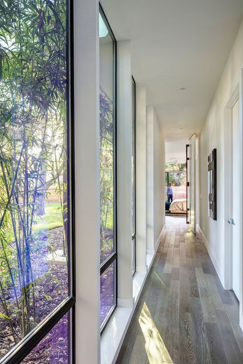 This modern hallway with floor-to-ceiling windows connects the master bedroom with the rest of the house. Bedroom Lighting Ceiling Modern, Bedroom Lighting Ceiling, L Shaped House Plans, U Shaped Houses, L Shaped House, Modern Family House, تصميم للمنزل العصري, Casa Country, Modern Hallway