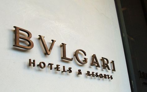 The way the logo extrudes off of the wall makes it stand out but at the same time, the color of the logo blends in well. A change in font would definitely be needed to a more rounded/leisure style. Hotel Signage Exterior, Luxury Signage, Bulgari Hotel, Bvlgari Hotel, Hotel Sign, 3d Signage, Hotel Signage, Entrance Signage, Brand Inspiration Board