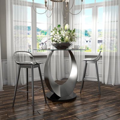 Enhance Your Dining Area With Our Exquisite 42" Round Dining Table. The Fluid U-Shaped Legs And Sleek Glossy Black Base Make A Striking Visual Statement. The 10Mm Thick Tempered Glass Top Adds A Touch Of Sophistication And Is Easy To Clean, Making It Ideal For Everyday Use. Immerse Yourself In Contemporary Design With This Exceptional Dining Table. | Orren Ellis Dristy Counter Height 42" Pedestal Dining Table Glass / Metal in Black / Gray | 36 H x 42 W x 42 D in | Wayfair Mirror Dining Table, Round Counter Height Table, Round Glass Dining Table, Dining Table Glass, Metal Base Dining Table, Glass Round Dining Table, Pedestal Table Base, Dinning Set, Glass Top Dining Table