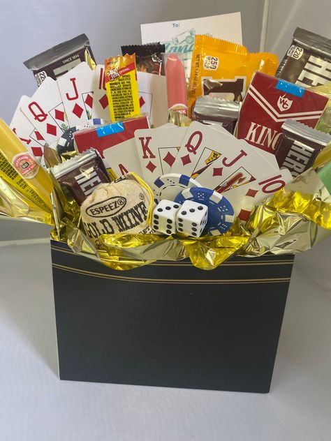 The perfect center piece or gift for poker night or casino night events. A black and gold gift box filled with full sized candy bars and themed decorations: dice, cards, poker chips. Sample candy includes candy cigarettes, gum cigars, candy bars. Candy may vary. We use several colors of solid color boxes. During warm weather months, hard candy will be substituted for chocolate. Photo is a sample, your item will be custom made for your order. Poker Themed Gift Basket, Gifts For A Gambler, Casino Gifts Ideas, Poker Gift Basket, Casino Gift Basket, Basket Raffles, Diy Alcohol Gifts, Prize Baskets, Benefit Ideas