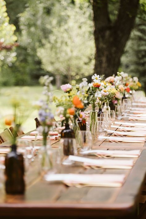 Colorful Spring Wedding Reception Decor | Whimsical, colorful outdoor wedding reception set up. The long table is beautifully decorated with vibrant flowers and set with peach-colored napkins. Discover whimsical wedding centerpiece, whimsical wedding color palette, mountain wedding colors and wedding reception aesthetic. Book Nina for your Colorado wedding or adventure elopement at larsenphoto.co! Farm Table Flowers Wedding, Simple Backyard Wedding Reception Decor, Long Table Outdoor Party, Single Table Wedding Reception, Long Wedding Table Ideas, Farm Table Reception, Simplistic Outdoor Wedding, River Wedding Reception, Farm House Table Wedding