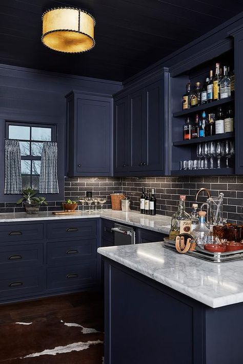 Dark blue bar cabinets with oil rubbed bronze knobs paired with black staggered backsplash tiles are lightened with white marble countertops. Dark Blue Cabinets, Kitchen Colors Schemes, Dark Blue Kitchen Cabinets, Blue Kitchen Interior, Navy Blue Kitchen Cabinets, Bathroom Transitional, Dark Blue Kitchens, Navy Blue Kitchen, Unique Kitchen Backsplash