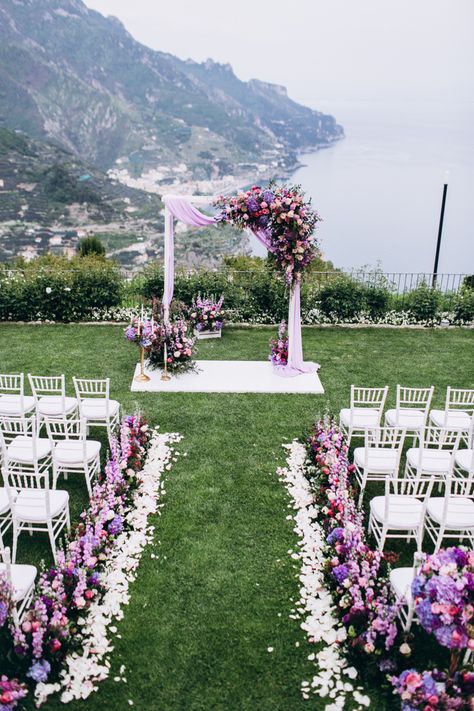 Stunning wedding arch and aisle decor with gorgeous purple florals and fabric draping. Fabric Draping Wedding, Wedding Ceremony Places, Purple Wedding Ceremony, Lilac Wedding Themes, Lavender Wedding Theme, Rapunzel Wedding, Wedding Aisle Outdoor, Purple Wedding Decorations, Draping Wedding