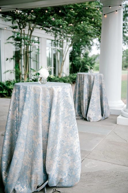 Blue Patterned Tablecloth Wedding, Blue Linen Tablecloth Wedding Reception, Blue Floral Linen Wedding, Green Draping Wedding, Tall Cocktail Tables Wedding, Blue Pattern Tablecloth Wedding, Blue And White Cocktail Table, Dusty Blue Cocktail Table, Alternating Centerpieces Wedding