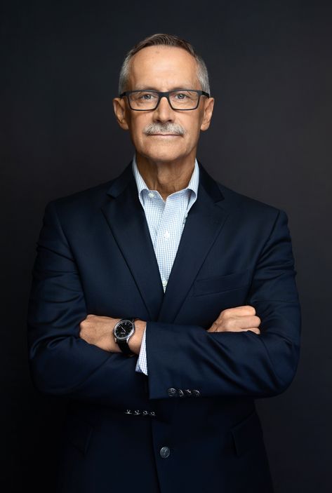 Business headshot of mature man wearing glasses with arms crossed smiling. Headshots Older Man, Ceo Portraits Men, Linkedin Headshots Men, Headshots For Pastor, Standing Headshot Poses Men, Mens Headshots Casual, Husband Wife Business Photoshoot, Corporate Poses For Men, Corporate Portrait Man