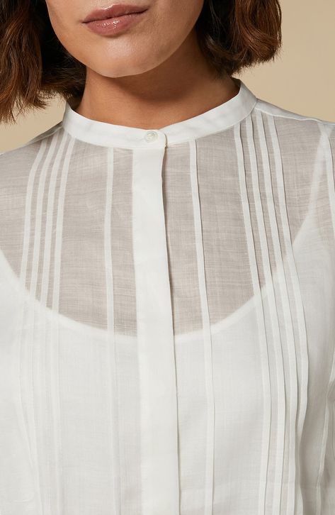 This sheer canvas shirt is designed with tucked pleats and a solid cami lining. 24" length Band collar Long sleeves with button cuffs Camisole lining 100% ramie Hand wash, line dry Imported Chemise, White Shirts, Band Collar Shirt, Banded Collar Shirts, Essential Wardrobe, White Shirts Women, Pleated Shirt, Shirts Women, Band Collar