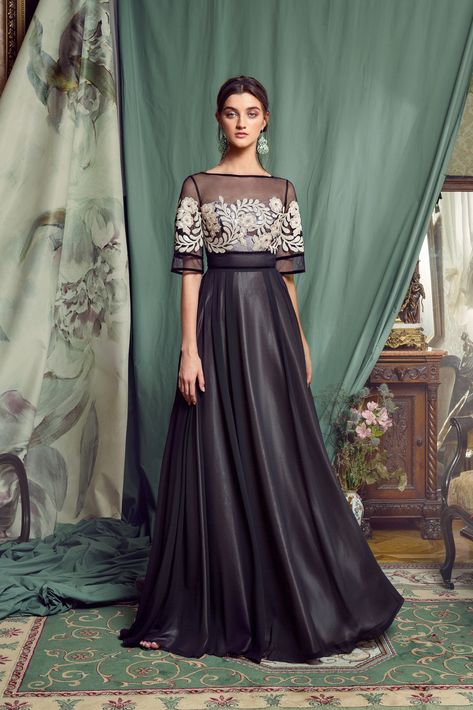 Style #453 is an elegant evening gown with ivory embroidery, sheer black fabric constructing the neckline and shoulders, and long satin black skirt. Classy Evening Gowns, Shrug For Dresses, Designer Evening Gowns, Evening Gowns Elegant, فستان سهرة, Gala Dresses, Gowns Of Elegance, Indian Fashion Dresses, Long Gown