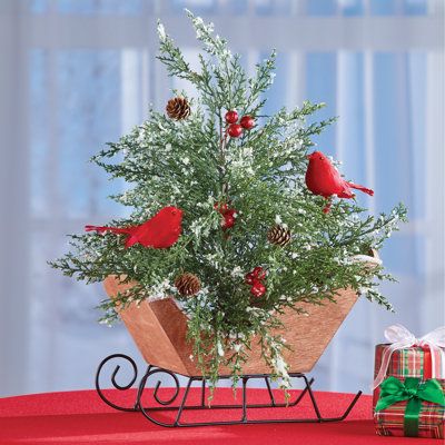 This charming wooden sleigh overflows with holiday cheer! Inside is a beautiful arrangement that includes a frosted pine tree accented with pinecones, berries and bright red cardinals. It's perfect as a holiday centerpiece or displayed atop a mantel or shelf. Wood, metal and plastic. Natal, French Centerpieces, Sleigh Arrangements, Winter Floral Arrangements Centerpieces, Holiday Centerpieces For Tables, Santa Sleigh Decoration, Christmas Floral Centerpieces, Christmas Sleigh Centerpiece, Christmas Sleigh Decorations