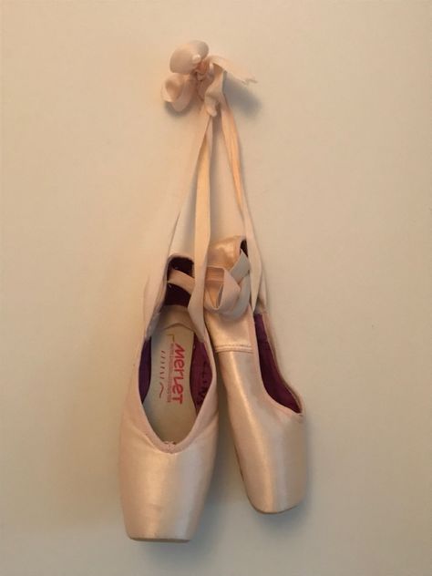 Pair of pointe shoes hanging on a white wall. Hanging Pointe Shoes, Pretty Pointe Shoes, Point Shoes Tattoo, Point Shoes Aesthetic, Ballet Brochure, Pointe Shoes Aesthetic, First Pointe Shoes, Pointe Shoes Photography, Ballerina Pointe Shoes