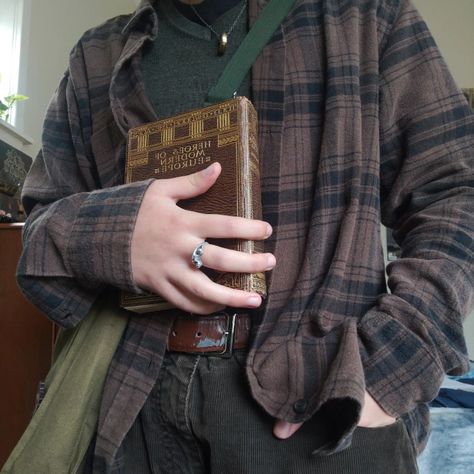 an outfit consisting of a brown checkered shirt over green sweater tucked into brown pants. the person is wearing this outfit and holding an old book. Fall Mens Aesthetic, Mens Fall Outfits Dark Academia, Fairygrunge Sweater, Goblincore Profile Picture, Cryptidcore Academia, Dark Academia Gender Neutral, Goblincore Dark Academia, Chaotic Academia Outfits Masc, Goblincore Men Outfits