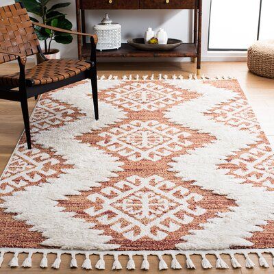 This area rug grounds your space in a bright pattern and fun texture. It's power-loomed from polypropylene that's made to be stain- and mildew-resistant. The rustic design features geometric patterns inspired by Southwestern textiles, with an orange base and white, fluffy zig-zag lines. We love that the high-low pile height and playful tassels add dimension to your floors while providing extra cushion and coziness - ideal for your bedroom or den. Pick up a rug pad to help keep it in place underf Shaggy Rugs, Living Room Orange Accents, Cozy Bright Living Room, Braided Fringe, Southwestern Area Rugs, Shag Rugs, Ivory Area Rug, Boho Living, Boho Designs