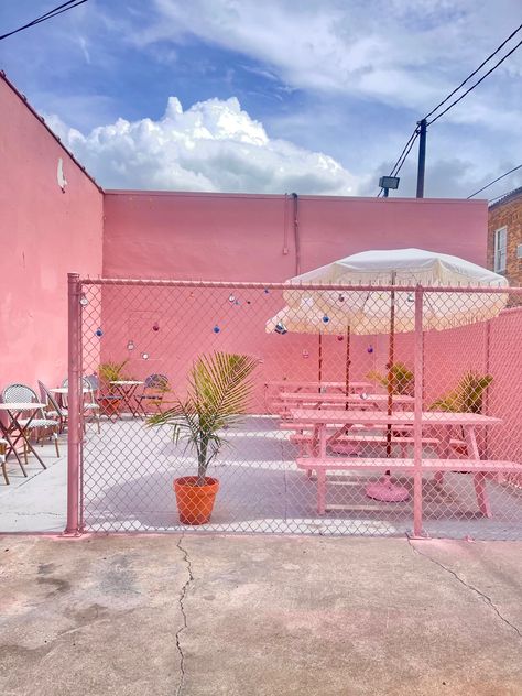 Pink patio with love locks and palm trees Pink Container Cafe, Pink Cafe Design, Pink Cafe Interior, Pink Cafe Aesthetic, Pink Outdoor Furniture, Outdoor Cafe Design, Pink Coffee Shop, Pink Backyard, Coastal Cafe