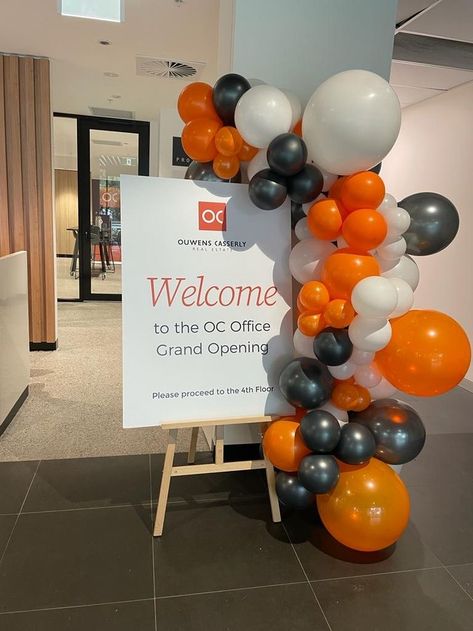 Orange, white and black balloon decor Networking Event Decor Ideas, Event Decoration Ideas Creative Simple, Event Decor Corporate, Office Opening Decoration Ideas, Flyer Display Ideas, Corporate Brunch Event, Corporate Open House Ideas, Launching Event Decoration, Conference Table Centerpiece Ideas