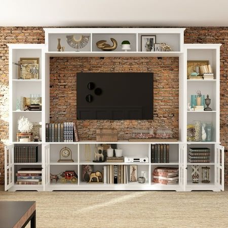 This wall unit features a 68 /102inch console, two pier units and an overhead bridge providing ample storage options. This 68/102 inch unit features gunmetal finished knobs, glass doors with wood framing, open storage, adjustable shelving. Tops and ends are solid planked panels, oversized thick tops and parting rails. (68"NOT INCLUDE 2 Side Cabinet) Features Four piece unit consists of two piers (left and right), a 66.5 console and 68.1" bridge Maximum Recommended TV Size: 65" Made of MDF, Tempered Glass Overall Dimensions: 102" W x 14.6" D x 78.2" H/68"W x 14.6"D Finish: White Size: 102"-WITH SIDECABINET - White. Dark Wood Tv Stand, Tv Shelf Ideas, Tv Cabinet Wall Design, Black Living Room Set, White Living Room Set, Grey Living Room Sets, Tv Nook, Living Room Nook, Tv Wall Cabinets