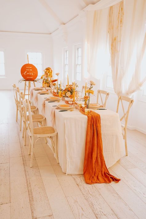 golden wedding table decor with an orange table runner, yellow taper candles and flower arrangements and gold cutlery Orange And Gold Table Decor, Yellow And Orange Tablescape, Orange And Yellow Decorations, Orange And Yellow Table Setting, Shades Of Orange Party Decor, Orange White And Gold Decorations, Orange Theme Decoration, Orange And Gold Wedding Decorations, Orange Theme Table Decor