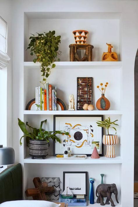 20 Travel-Inspired Decorating Ideas to Evoke Your Favorite Destination Bookshelf Decor Colorful, Home Decor Ideas Shelves, Floating Shelf Decor Colorful, Shelf Styling Colorful, Shelf Styling Maximalist, Colorful Shelves Decor, Shelf Decor Bedroom Colorful, Shelf Decor Living Room Eclectic, Bookshelf Styling Colorful