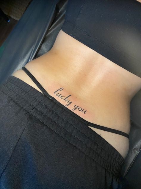 Lucky You Tramp Stamp Tattoo, Lucky You Back Tattoo, Low Rise Tattoo, Unforgettable Tramp Stamp Tattoo, Deftones Tramp Stamp, Tramp Stamp Ideas Classy, Tramp Stamp With Words, Tramp Strap Tattoo, Ice Spice Tramp Stamp