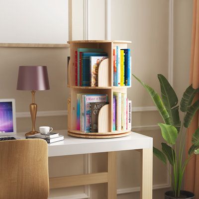 This 360-degree rotating bookshelf is made with high-quality solid wood. Featuring a 4-tier design, you can organize a variety of different items with ease such as books, vases, albums, etc. With a modular stackable design, you can also remove levels from the bookshelf and fit them into small spaces. | Latitude Run® Solid Wood Standard Bookcase Brown 27.0 x 18.0 x 18.0 in | C010997197_1088480038 | Wayfair Canada Organisation, Portable Book Shelf Ideas, Book Storage Ideas For Small Spaces, Bookshelf Inspo, Bookshelves For Small Spaces, Rotating Bookshelf, Bedroom Bookcase, Small Apartment Storage, Round Desk