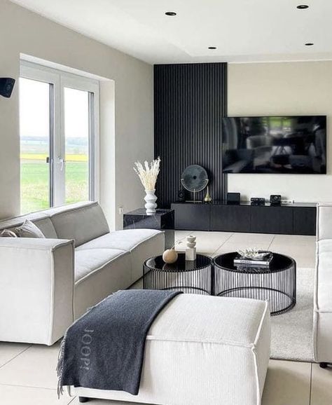 Are you a newbie in designing a dark accent wall but intrigued by its beauty? Check out this design! Instead of painting the entire wall in black, you can choose wall panels and install them halfway up the wall. #BlackWallDecor #DarkFeatureWall #BlackWallIdeas #MinimalistBlackWall #DarkWallPaint #BlackLivingRoomWall #BedroomFeatureWall #BlackWallTrends #LuxuriousBlackWalls Bloxburg Basement, Black Living Room Decor, Modern Apartment Living Room, Bar Basement, White Apartment, تصميم داخلي فاخر, Black And White Living Room, Decor Fireplace, Apartment Living Room Design