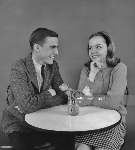 News Photo : A teenage couple sitting at a bistro table... Flirting Poses, Sitting Pose Reference, Teenage Couples, Couple Sitting, Sketchbook Inspo, Dvd Cover, Comic Layout, Anatomy Poses, Sitting Poses
