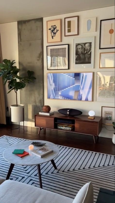 Minimalstic, modern, living room, nyc apartment, gray apttern tug, wooden floors, round coffe table, wooden TV stand, plants in room, art work, wall art, living room painting, living room wall art, 2023 trendy aperment, y2k, interior design, home decor, apartment inspo, home decor inspo, plants, furniture, art, table decoration Y2k Interior Design, Plants In Room, Y2k Interior, Living Room Nyc, High Rise Apartment Decor, Indoor Plants Aesthetic, Wall Art 2023, Warm Living Room Decor, Artsy Home