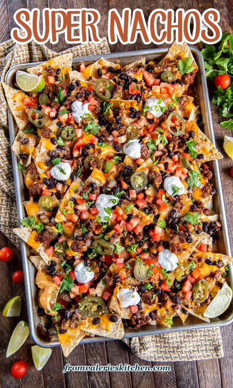 These sheet pan Super Nachos are loaded with ground beef, black beans, homemade nacho cheese sauce, and plenty of freshly shreddded cheese. Just pile on your favorite toppings and dig in! Game Day Nachos Ground Beef, Essen, Grilled Nachos Recipe, Authentic Mexican Nachos Recipe, Black Bean Nachos Recipe, Diy Nachos Ground Beef, Nacho Recipes Beef, Fully Loaded Nachos, Halloween Nachos Ideas