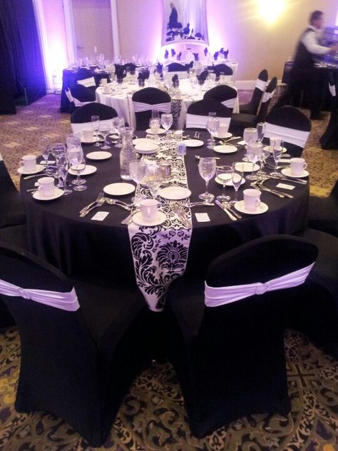 Black spandex chair cover with white band and broach and damask runners! Www.eleg.com Black And Lilac Quinceanera Theme, Black Chair Covers Wedding, Grad Themes, Quinceañeras Ideas, Black Chair Covers, 50th Birthday Party Themes, Black Seat Covers, Black Party Decorations, Damask Decor