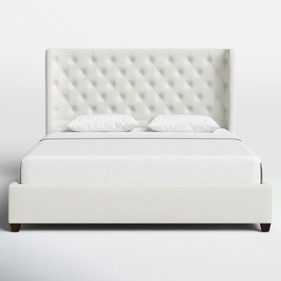 The Naveen bed collection is a chic platform-style bed frame with a tall, statement-tufted headboard that is perfect for any master suite or bedroom. The headboard is tall and accommodates any thickness of the mattress while the curved, wingback design brings a modern touch. The headboard, side, and foot rails, and center support slats are included so no box spring is required. Color: Antique White | Birch Lane™ Naveen King Tufted Upholstered Platform Bed Polyester in White | 51.5 H x 81 W x 85 Tufted White Bed, Tall Mattress Bed, White Leather Bed Frame, White Tufted Headboard, White King Bed, White Leather Bed, Tall Bed Frame, Modern Queen Bed, White Queen Bed
