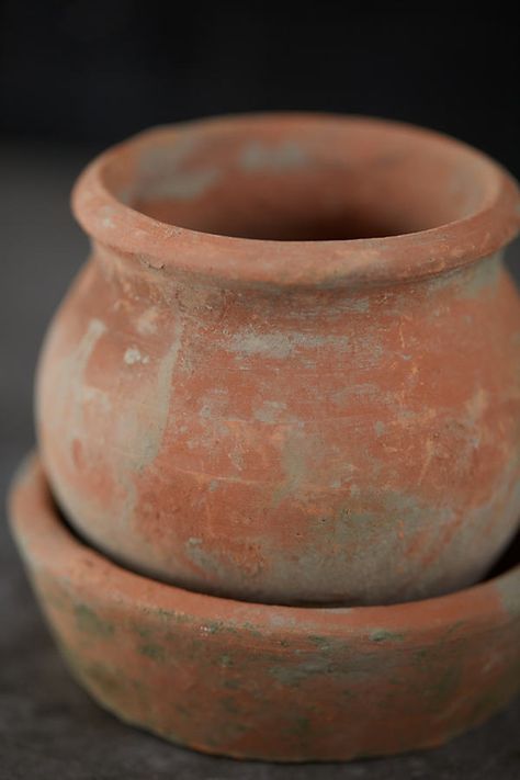 Using a primitive firing technique that has been refined over thousands of years, these clay pots are handmade in Asia. Before firing, each piece is wrapped in linen and slowly dried, lending a beautifully imperfect, aged finish. Hand-crafted for one-of-a-kind appeal, each Earth Fired pot + saucer set is made from clay with a highly variable mineral content, which can cause color variation from pot to pot. During a unique aging process, natural moss develops on the surface of the pot for an anti Homemade Clay Pots, Aged Terra Cotta Pots, Earthen Pots, Pottery Plant Pots, Antique Pots, Vintage Terracotta Pots, Aging Terra Cotta Pots, Handmade Clay Pots, Modern Parisian