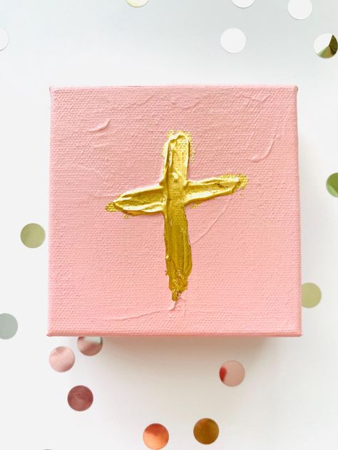 Painted on small stretched canvas, this gold-colored foil Cross painting is the perfect addition to add a touch of shimmer and simple elegance to any room, shelf, or desk. This simple Cross blends nicely with any decor style and would be the perfect addition to a baby nursery or as a wedding gift. The Cross and gold foil are accented by dimensional texture and a cheerful neutral pink background. The canvas has gallery edging which allows it to stand up by itself without a frame or brackets. This piece is a one-of-a-kind from our collection of Faith artworks. ❤ We also offer boutique-style gift wrap as an option! Please see that as a separate item in our store and add it on before purchasing.❤ ✔ FREE SHIPPING - Current Shipping Times: About 3 business days- USA Only (If you need the item so Neutral Pink Background, Cross Artwork, Cross Painting, Room Shelf, Neutral Pink, Christian Home Decor, Pink Cross, Simple Cross, Cross Art