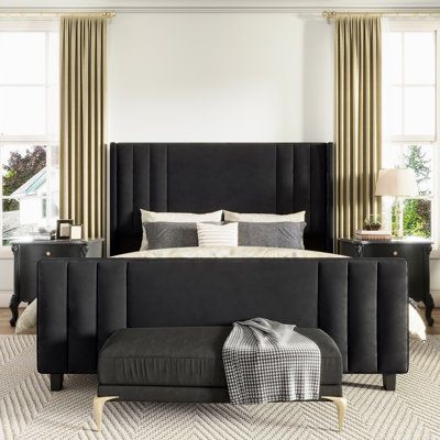 This clean-lined platform bed features a glam wingback headboard with channel tufting, creating a bold statement in your bedroom. Upholstered in luxurious velvet in a neutral hue, this bed is both stylish and cozy. The frame is made from engineered wood, and it rests on short tapered feet for a mid-century silhouette. We love how the finished back makes for easy placement in any sleep space. Plus, with 12 slats and two center support legs, there's no need for a box spring. Just add your favorite Beds With Footboard Master Bedrooms, Grey Black And Gold Bedroom, Bed Frames Black, Tall Bed Frame, Channel Tufted Headboard, Black Bed Frame, Tall Bed, Headboard Upholstered, Lit King Size