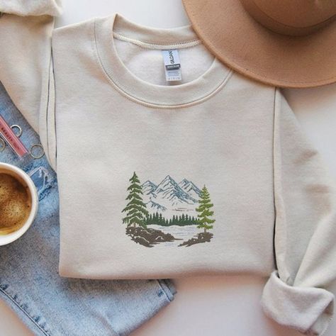 Forest Pine Trees and Mountains Lake Embroidered Sweatshirt, Fall Sweatshirts Mountain Embroidery Shirt, Hand Embroidery Mountains, Embroidered Pine Tree, Embroidered Sweatshirt Ideas, Embroidery Mountains, Mountain Aesthetic Outfit, Embroidered Mountains, Mountain Clothes, Embroidery Sweaters