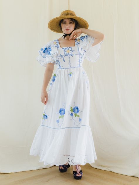 Our Floral Embroidered Maxi Dress is a stunning and one-of-a-kind piece, perfect for any occasion. Made from various vintage textiles, this dress features a square neck, flared tier dress, and ruffle sleeves that give it an airy and feminine look. The linen/cotton fabric is adorned with simple floral embroidery and a fabric belt at the waist that creates a flattering silhouette.   The even tier hemline with lace detailing adds a touch of elegance to this perfect dress. Pair it with strappy heels Floral Patchwork Dress, Simple Floral Embroidery, Simple Maxi Dress, Reworked Clothes, Simple Maxi, Clothes Upcycle, Upcycle Ideas, Tier Dress, Bedroom Setup