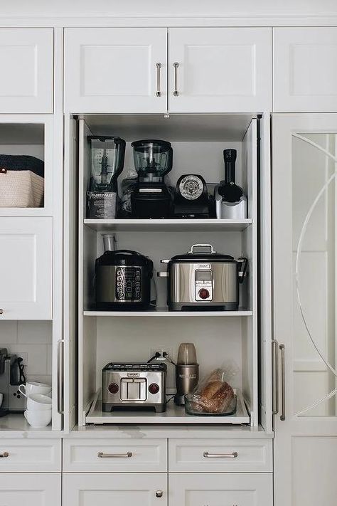 Fitted with pull out shelves, a small appliances cabinet is finished with white doors and nickel hardware and fixed beneath a white over head cabinet. Organisation, Kitchen Appliances Cabinet, Cabinet With Pull Out Shelves, Charcoal Gray Kitchen Cabinets, White Kitchen Drawers, Appliances Cabinet, White Kitchen Shelves, Gorgeous White Kitchen, Kitchen Appliance Storage