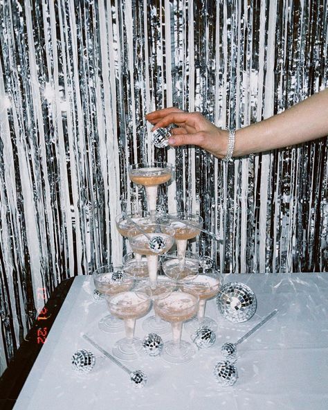 Sparkling shimmery background with disco balls placed on and around champagne tower Disco Theme 21st Party, Disco 25th Birthday, Bachelorette Champagne Tower, Glitz And Glam Birthday Theme, Glitter Birthday Decorations, Silver Disco Birthday Party, Sparkles Birthday Party Theme, White And Shimmer Party, Bachelorette Party Silver