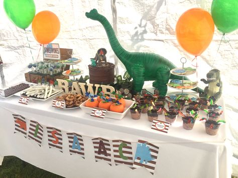 Dinosaur birthday party .  Dinosaur dessert table .  Inflatable dinosaur I got from Amazon . The rest of the desserts are home made . Dinosaur Desert Table, Dinosaur Table Setting, Dinosaur Dessert Table, Glass Dinosaur, Dinosaur Snacks, Dinosaur Table, Birthday Party Dinosaur, Inflatable Dinosaur, Jurassic Park Birthday