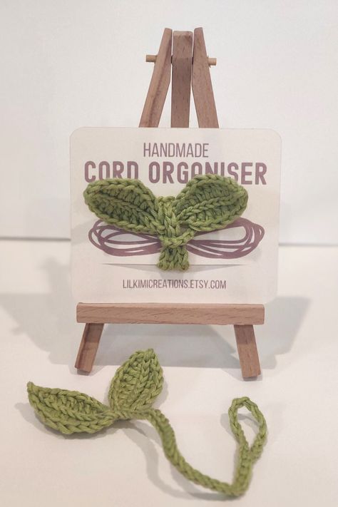 Crochet Leaf Sprout Cord Organiser - the perfect blend of functionality and nature-inspired beauty! Tired of tangled cords and cables cluttering your space? Our handmade cord organiser is here to bring order and a touch of whimsy to your daily life. 🌿 **Nature-Inspired Design Crafted with love, this cord organiser features a delightful crochet leaf sprout design, adding a touch of natural elegance to your desk, office, or living space. The intricate details make it not just a practical accessory but a visual treat as well. 🔗 **Clever Cord Management Say goodbye to the frustration of untangling cords! Our organizer is designed to keep your charging cables, earphones, and other cords neatly in place. The leaf sprout design acts as individual slots, providing a secure and stylish way to man Crochet Charging Cord, Crochet Cord Organizer, Crochet Phone Charger Cords, Leaf Sprout Crochet, Crochet Desk Accessories, Sprout Crochet, Start Crocheting, Finger Knit, Crochet Leaf